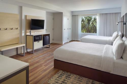 SpringHill Suites by Marriott Pensacola Beach في شاطئ بينساكولا: غرفة فندقية بسريرين وتلفزيون بشاشة مسطحة