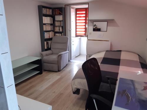 ein Wohnzimmer mit einem Tisch und einem Stuhl in der Unterkunft Studio indépendant in Saint-Illiers-la-Ville