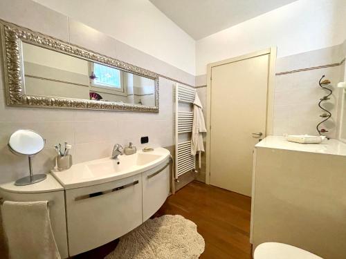 Baño blanco con lavabo y espejo en Volo di Libellula - close to the Lake and city centre, en Sarnico