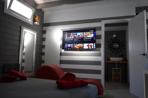 - une chambre avec un lit et une télévision murale dans l'établissement Chalet Puerto Escondido, à Telde