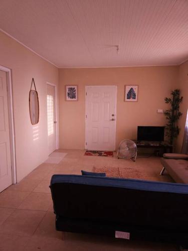 een woonkamer met een bank en een witte deur bij Sunset Breeze in Pointe Michel