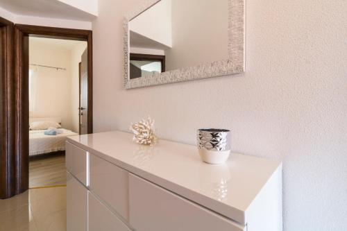 a white dresser in a bedroom with a mirror at Apartment Hilda in Solin