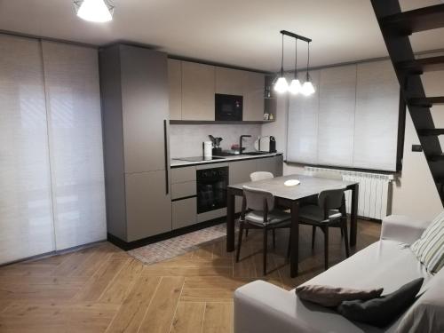 a living room with a table and a kitchen at Bardonecchia Apartment in Bardonecchia