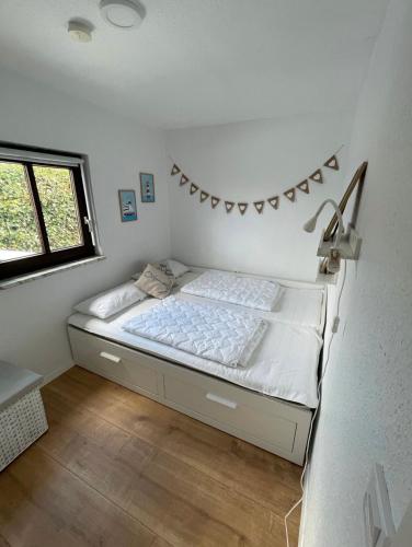 1 dormitorio con 1 cama con una pancarta en la pared en Haffkrug Beach Bungalow en Scharbeutz