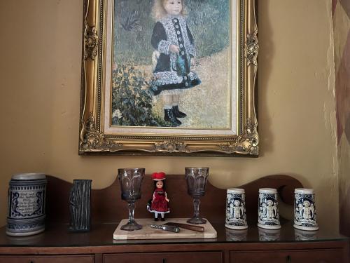 a painting of a girl on a shelf with wine glasses at Admiral Peary Inn in Fryeburg