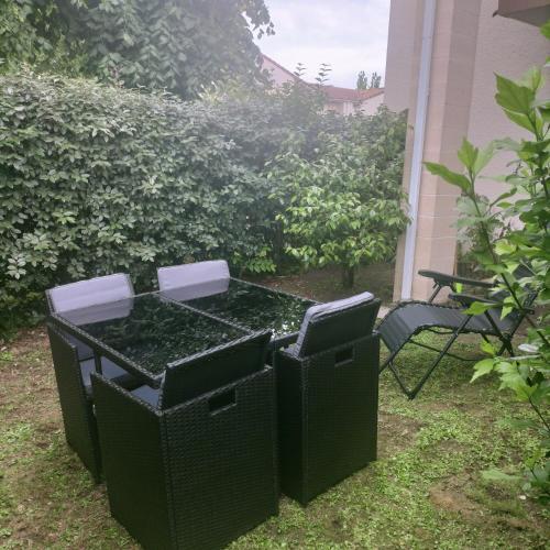 Duas latas de lixo pretas sentadas num quintal em Appartement aux portes de Bordeaux em Pont-de-la-Maye