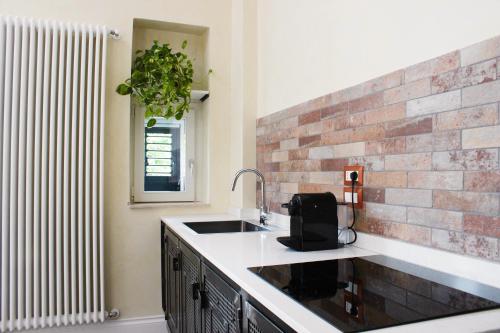 a kitchen with a sink and a brick wall at Suite I Tre Cardilli in Matera
