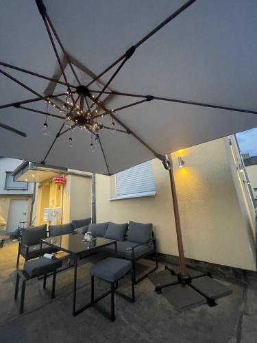 eine Terrasse mit einem Tisch, Stühlen und einem Sonnenschirm in der Unterkunft Ferienwohnung Marie in Rüdesheim am Rhein