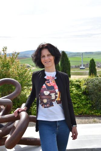 a woman is standing next to a sculpture at Lajatico Rentals - Terrazza sul Tramonto del Silenzio in Laiatico