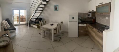 a kitchen with a table and a white refrigerator at Villa LILI in Rogoznica