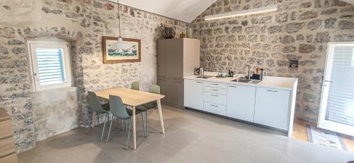 a kitchen with a table and chairs in a room at Skalina House in Tivat