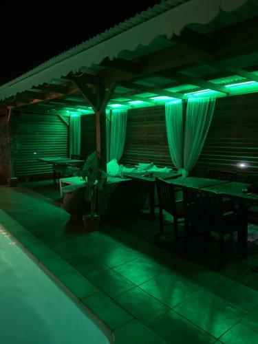a restaurant with green lights in the dark at Love Guadeloupe in Sainte-Anne