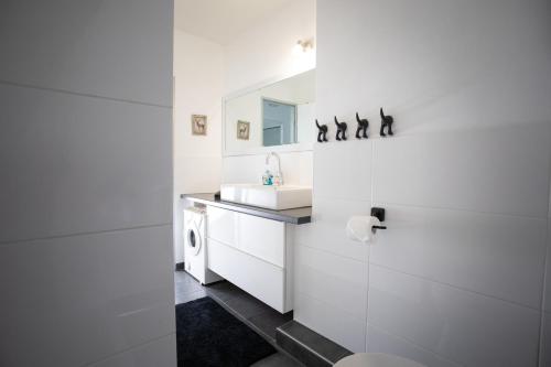 a white bathroom with a sink and a mirror at Ferienappartement Winterberg - Bikepark um die Ecke in Winterberg