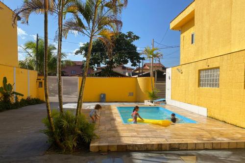 a group of children playing in a swimming pool at POUSADA AMARELA in Itanhaém
