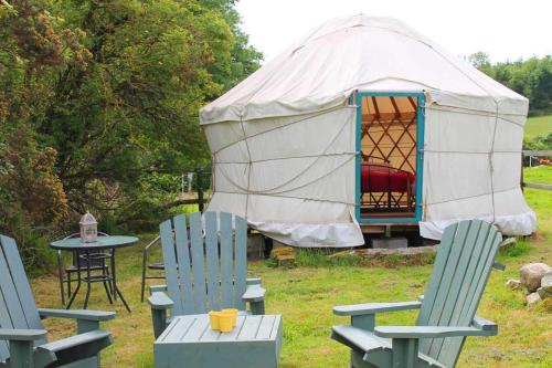 The Walled Garden Yurt في تولو: خيمة مع كراسي وطاولة وخيمة