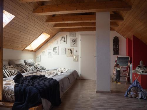 ein Kind steht in einem Schlafzimmer mit einem großen Bett in der Unterkunft Chata Laci na Kamenci in Kaluža