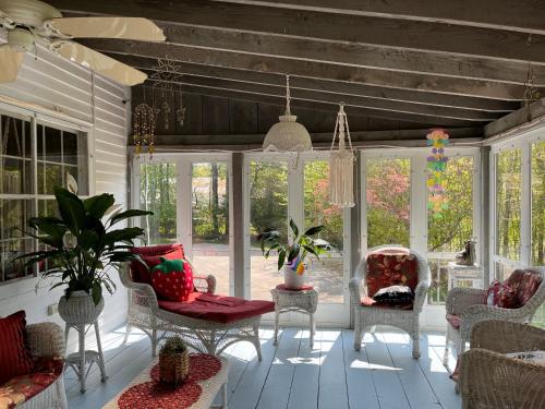 a screened in porch with chairs and a table at Admiral Peary Inn in Fryeburg