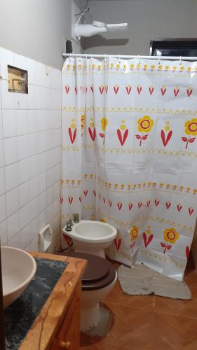 een badkamer met een toilet en een douchegordijn bij Como en casa in Campo Grande