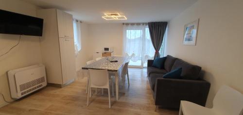 ein Wohnzimmer mit einem Esstisch und einem Sofa in der Unterkunft Appartamenti Lino in Caorle