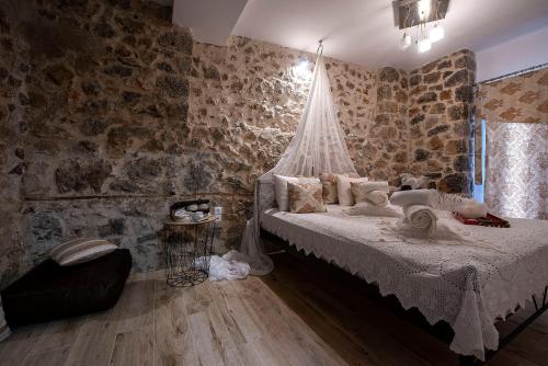 um quarto com uma cama e uma parede de pedra em Lilaia's View em Lílaia