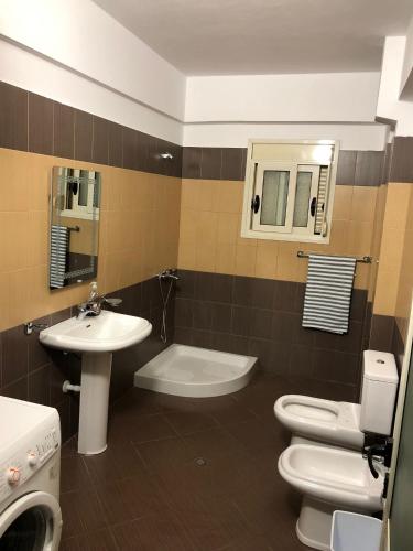 a bathroom with a sink and a toilet and a sink at Jon’s View Home in Vlorë