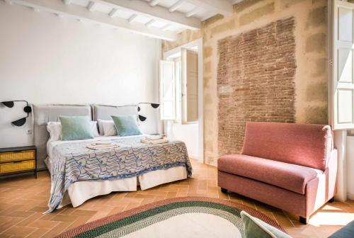 a bedroom with a bed and a chair at Casa Turqueta in Mahón