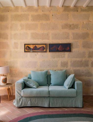 a living room with a couch against a brick wall at Casa Turqueta in Mahón