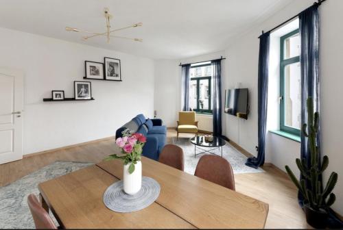 ein Wohnzimmer mit einem Tisch und einem blauen Sofa in der Unterkunft NEW Vintage Chic Apartment in Dresden