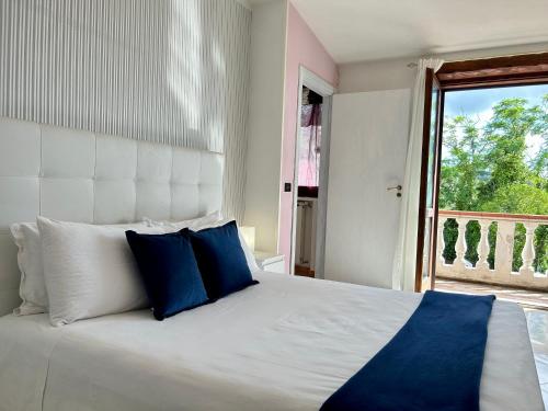 a bedroom with a large white bed with blue pillows at Dolce Basilico in Agropoli