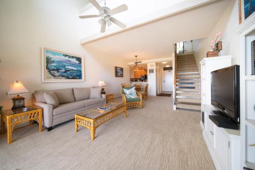 a living room with a couch and a tv at Kapalua Villas Maui in Lahaina
