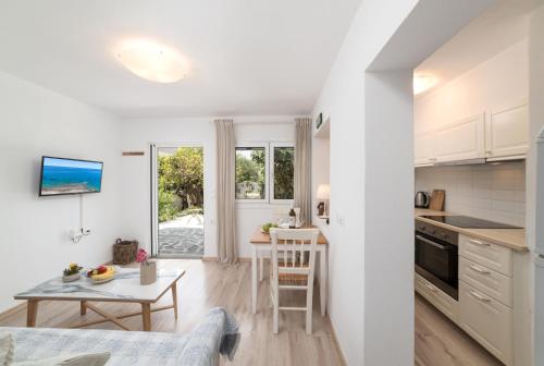 a kitchen and living room with a table and a dining room at Cozy Cottage in Istron