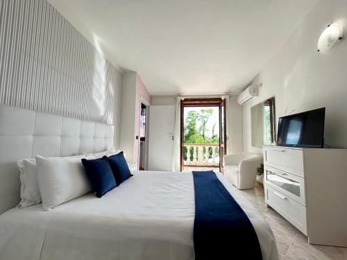 a bedroom with a large white bed with a television at Dolce Basilico in Agropoli