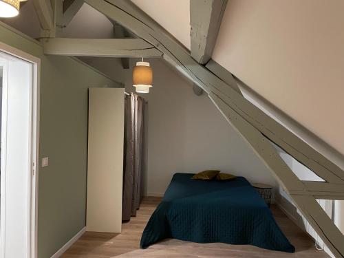 - une chambre mansardée avec un lit bleu dans l'établissement duplex dans le triangle d'or, à Compiègne