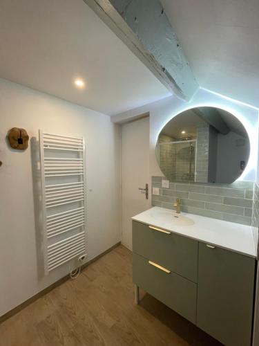 une salle de bain avec un lavabo et un miroir dans l'établissement duplex dans le triangle d'or, à Compiègne
