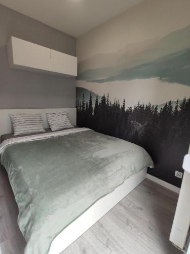 sypialnia z dużym łóżkiem z obrazem na ścianie w obiekcie Nowoczesny apartament dla par w Krakowie