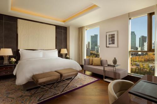 um quarto com uma cama grande e uma janela grande em The Ritz-Carlton, Astana em Astana