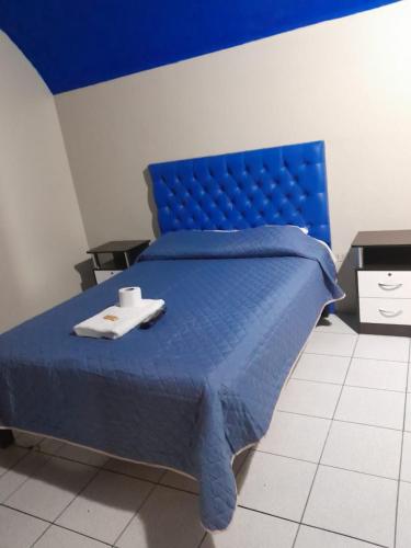 een blauw bed met twee handdoeken erop bij hostal flores in Arequipa