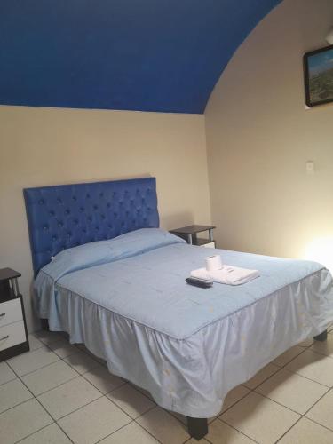 een bed met een blauw hoofdeinde in een slaapkamer bij hostal flores in Arequipa