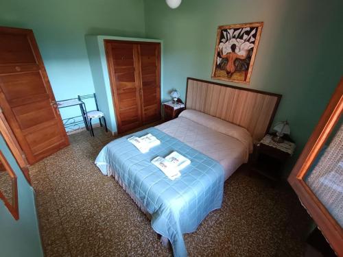 a small bedroom with a bed with a blue blanket at Castelar - Hotel & Apart in Huerta Grande