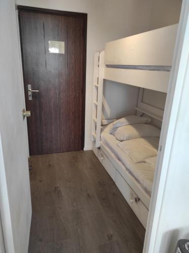 Cette petite chambre comprend 2 lits superposés et une porte. dans l'établissement Port studio piscine, parking, privé,navette aéroport, au Cap d'Agde