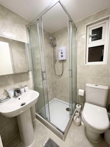 a bathroom with a shower and a toilet and a sink at Stylish 3-Bedroom Flat in Prime Location in London