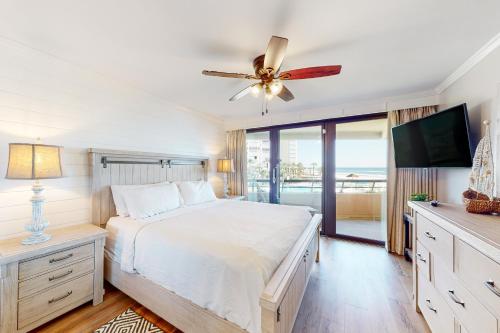 sypialnia z łóżkiem i wentylatorem sufitowym w obiekcie Edgewater Beach Resort 311 w mieście Destin