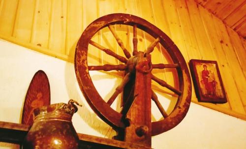 a large woodenoked wheel in a room with a wall at Poiana Sașilor - Valea Doftanei in Trăisteni