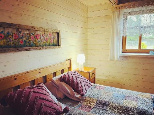 a bedroom with a bed in a wooden room at INNA BAJKA in Nowy Berezów
