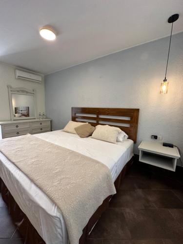 a bedroom with a large white bed and a table at VPX Hoteles Cieneguilla in Cieneguilla