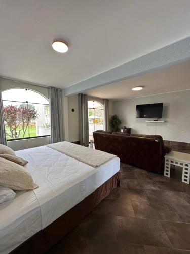 a bedroom with a large bed and a flat screen tv at VPX Hoteles Cieneguilla in Cieneguilla
