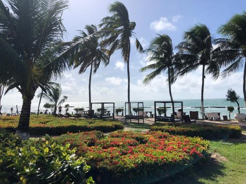 a park with palm trees and flowers on the beach at Praia dos Carneiros apart beira-mar in Tamandaré