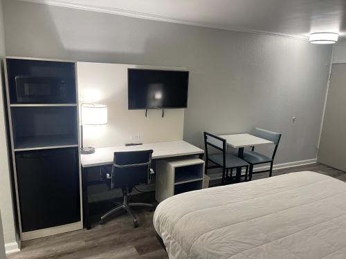 a hotel room with a bed and a desk and chairs at Quality Inn & Suites Georgetown in Georgetown