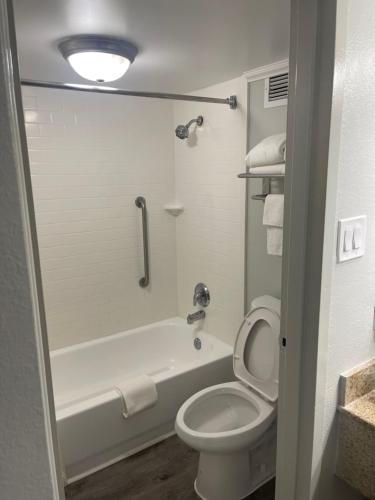 a bathroom with a toilet and a tub and a sink at Quality Inn & Suites Georgetown in Georgetown