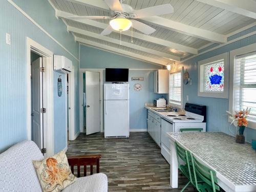 cocina con paredes azules y ventilador de techo en Blue Dolphin Inn and Cottages, en Grand Isle